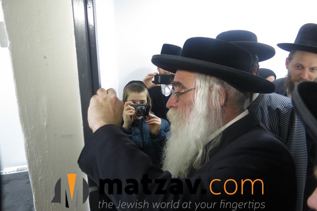 Rabbi Chaim Yosef Blau affixing a mezuzah.