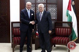 French Foreign Minister Laurent Fabius (L) shakes hands with President Mahmoud Abbas