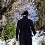 An Ultra-Orthodox Jewish man walks on a snow-covered street near Jerusalem's Old City