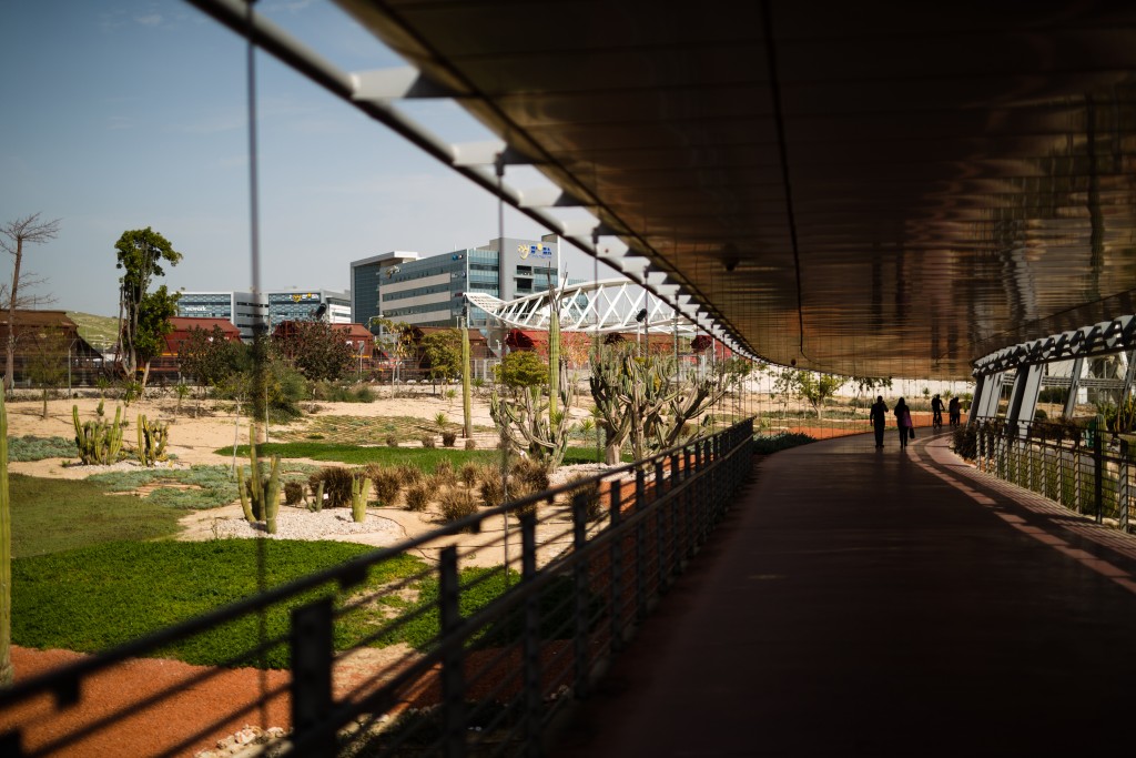 People are silhouetted as they stroll along a shaded walkway connecting Ben-Gurion University of the Negev to Gav-Yam Negev Advanced Technologies Park via a bridge in Beersheba, Israel. Must credit: Photo by David Vaaknin for The Washington Post